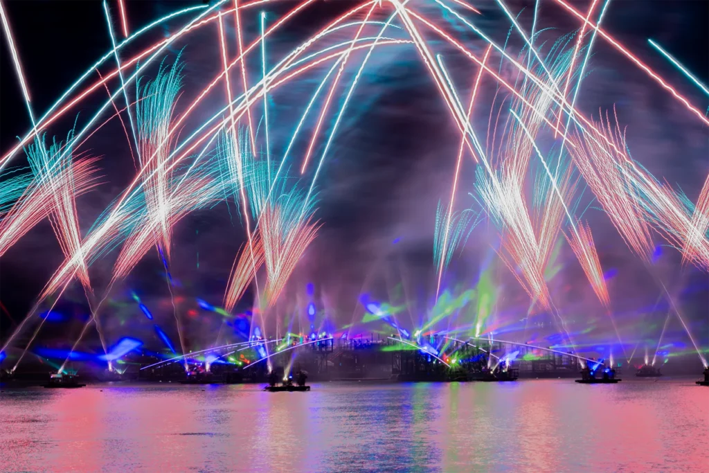 Colourful sweeping fireworks explode above the lagoon during an evening display at Epcot.